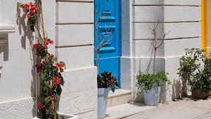 Un edificio con puerta azul, paredes blancas y el número 53.