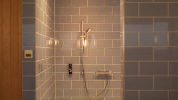 A shower with a handheld showerhead and a wall-mounted control panel.