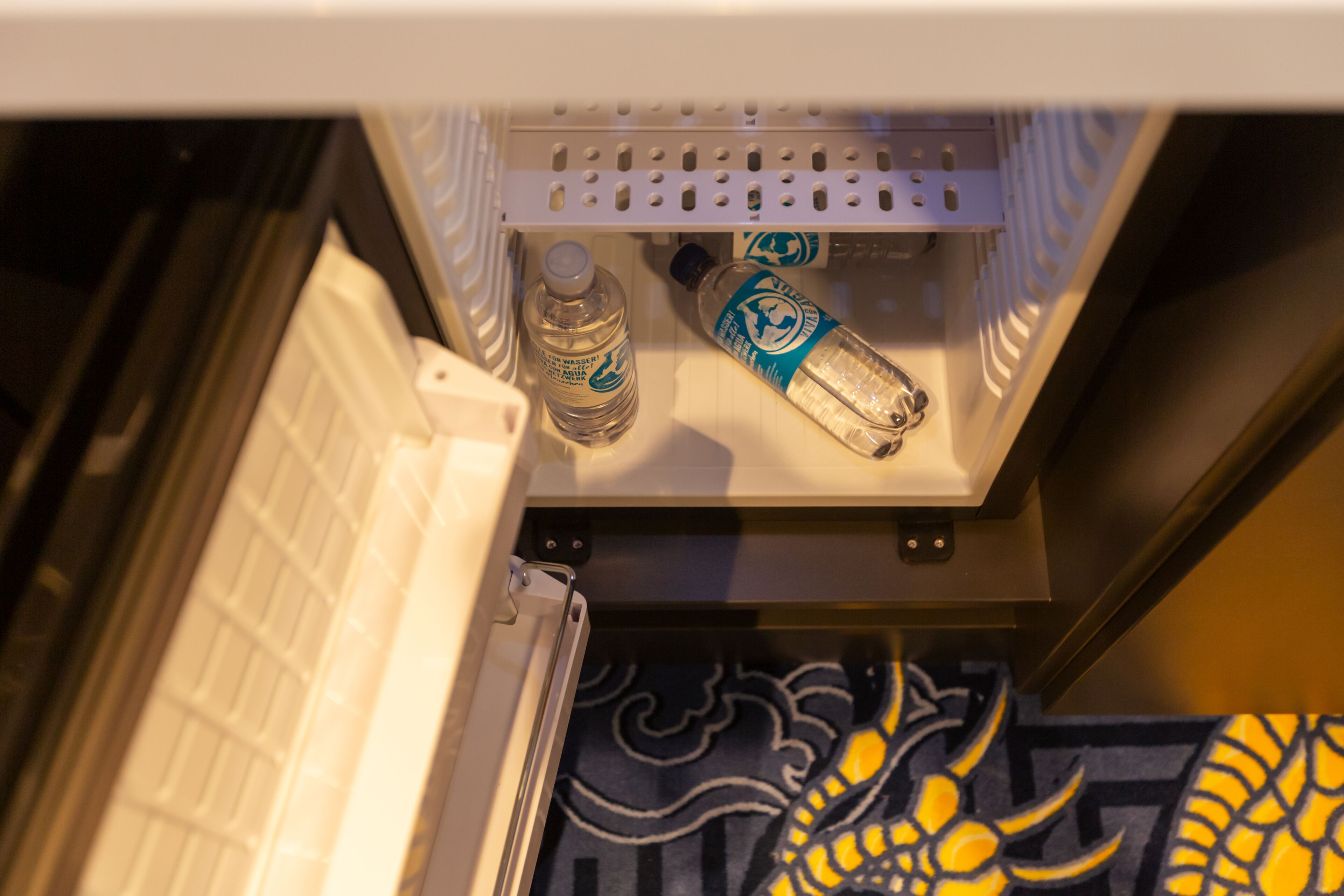 Ein Kühlschrank mit zwei Wasserflaschen und einer Flasche Wodka.