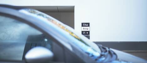 Un coche estacionado frente a un edificio con un letrero que dice "the nu".