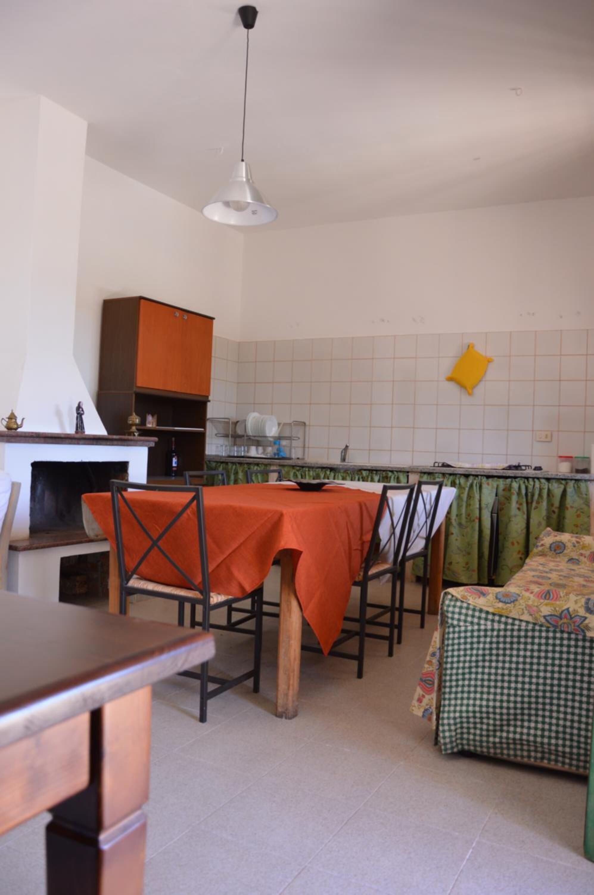 A compact kitchen with a dining table, chairs, and a sofa.