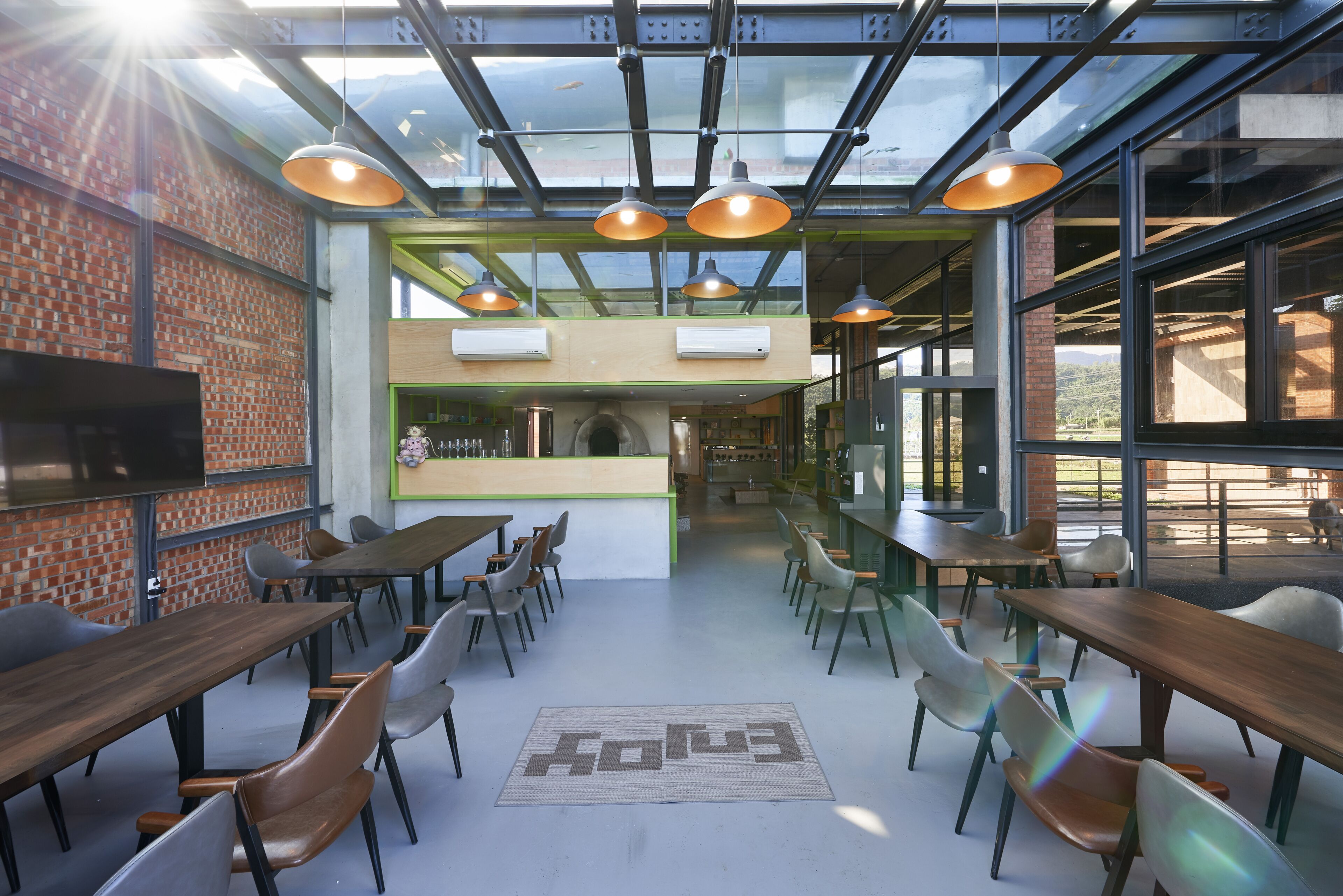 Un café moderne avec des murs en briques, des tables et des chaises en bois.