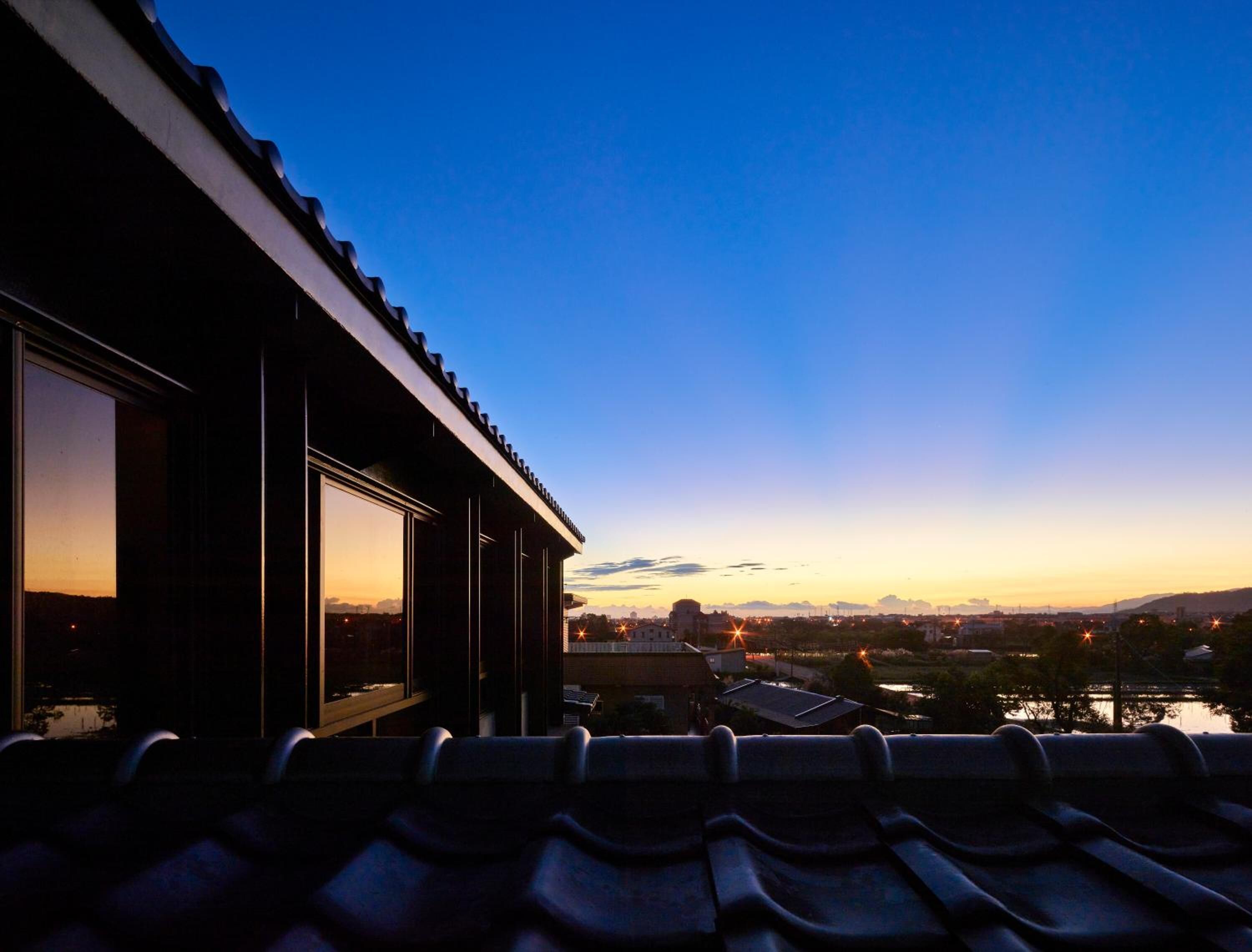 Vista desde un balcón sobre un paisaje urbano al atardecer.