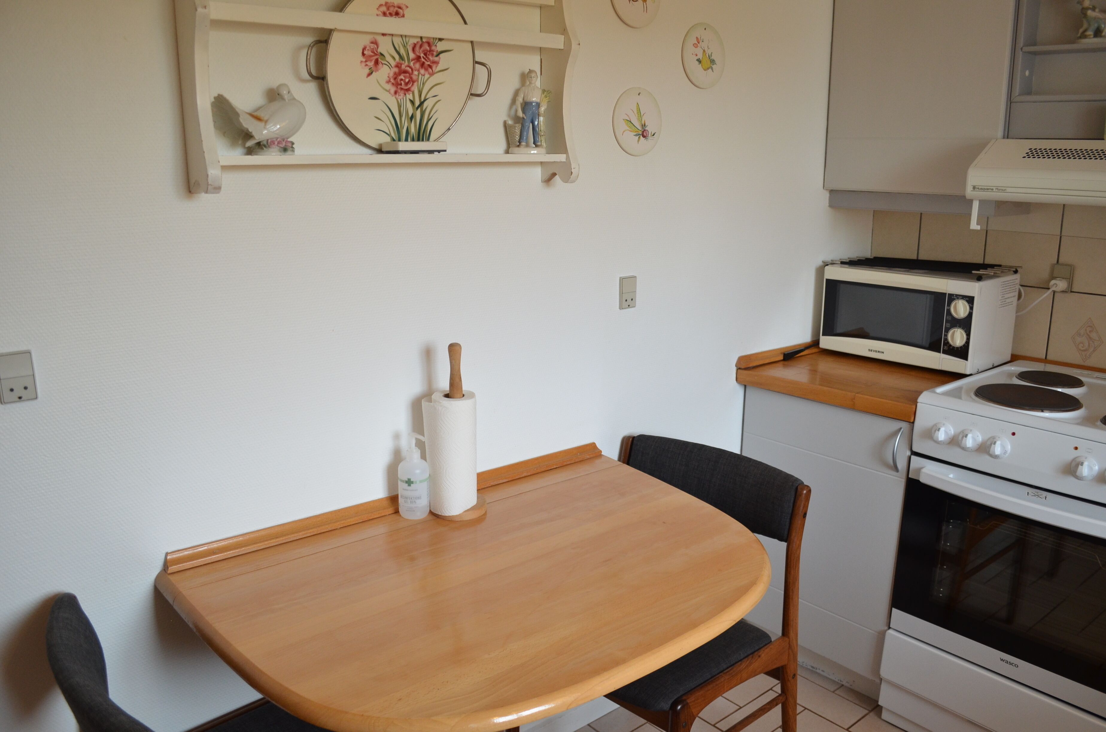 A kitchen with a wooden table, a microwave, and a stove.