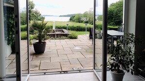 A modern interior with a sliding glass door leading to a patio area. - Naturperlen (Rodekro)