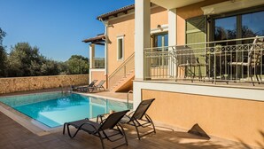 A swimming pool with lounge chairs, a staircase, and a balcony with a railing. - Private pool and sea view (Leivathou)