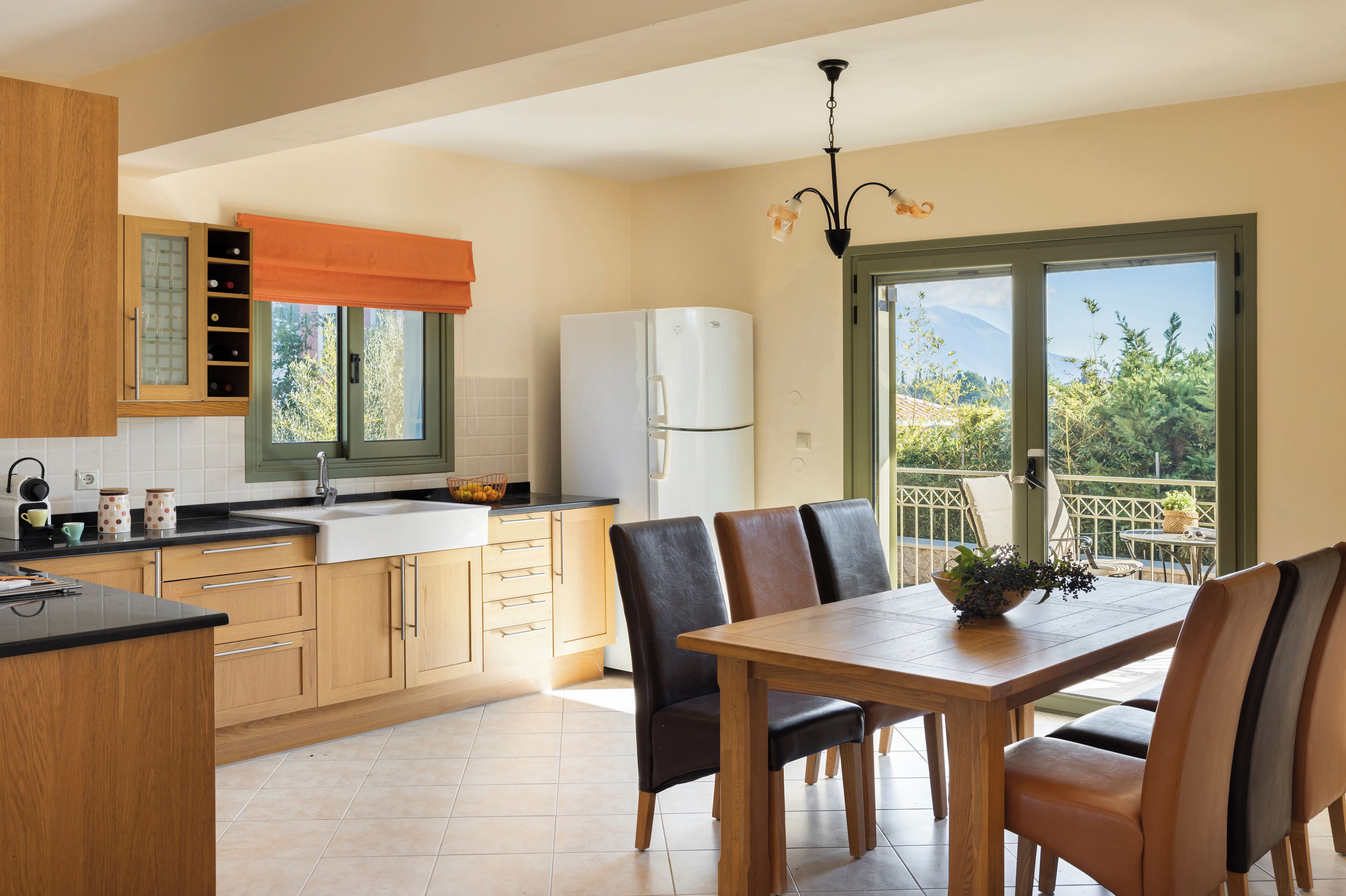 A modern kitchen with wooden cabinets, a white refrigerator, and a dining area with a wooden table and chairs.