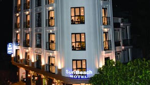 Un hotel de varios pisos con un diseño arquitectónico clásico, que cuenta con balcones y grandes ventanales.