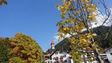 Ein Gebäude mit einem roten Turm, einem Restaurant namens "Restaurant Scruizer" und einem Berg im Hintergrund.