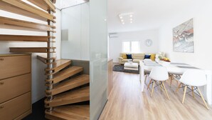 A modern interior with a spiral staircase, a dining area with white chairs, and a living space with a sofa and cushions. - Holiday Home Apartments Bellamare (Zadar)