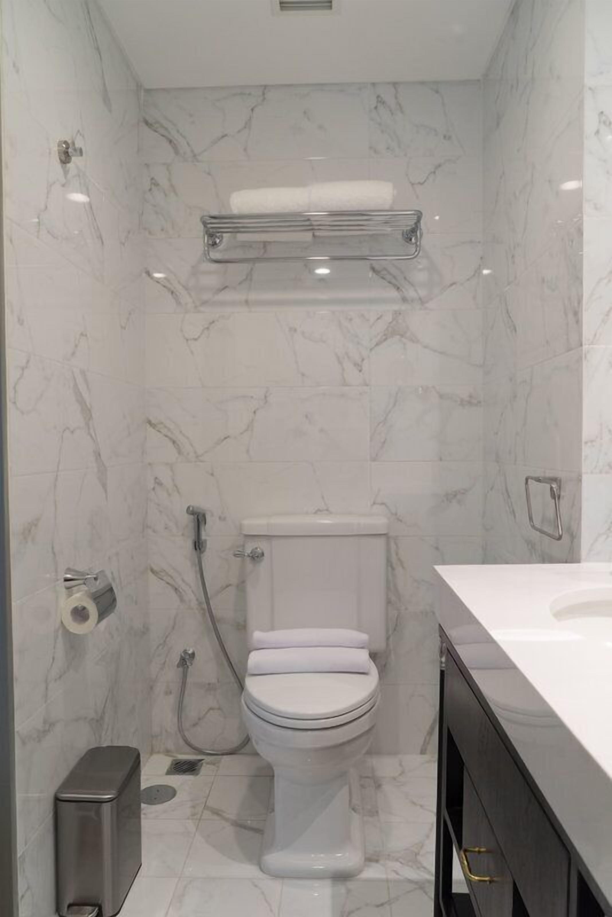 A bathroom with a toilet, a shower, and a sink.