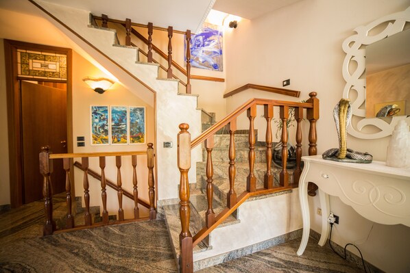 Un escalier avec des balustrades en bois et un sol en marbre.