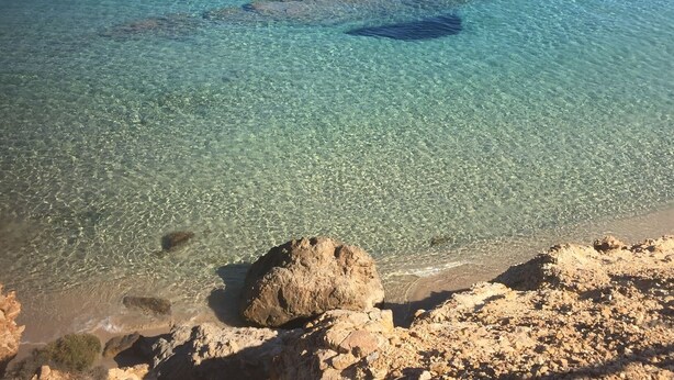 Una vista despejada de una costa rocosa con aguas poco profundas.