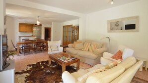 A living room with a sofa, coffee table, and a dining area with chairs and a table. - Holiday rental villa with swimming pool in Begur, Sa Tuna (Begur)