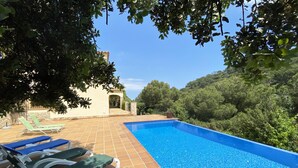 A swimming pool with lounge chairs, surrounded by trees and a clear sky. - Holiday rental villa with swimming pool in Begur, Sa Tuna (Begur)