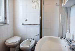 Bañera con ducha, secador de pelo, bidet, toallas