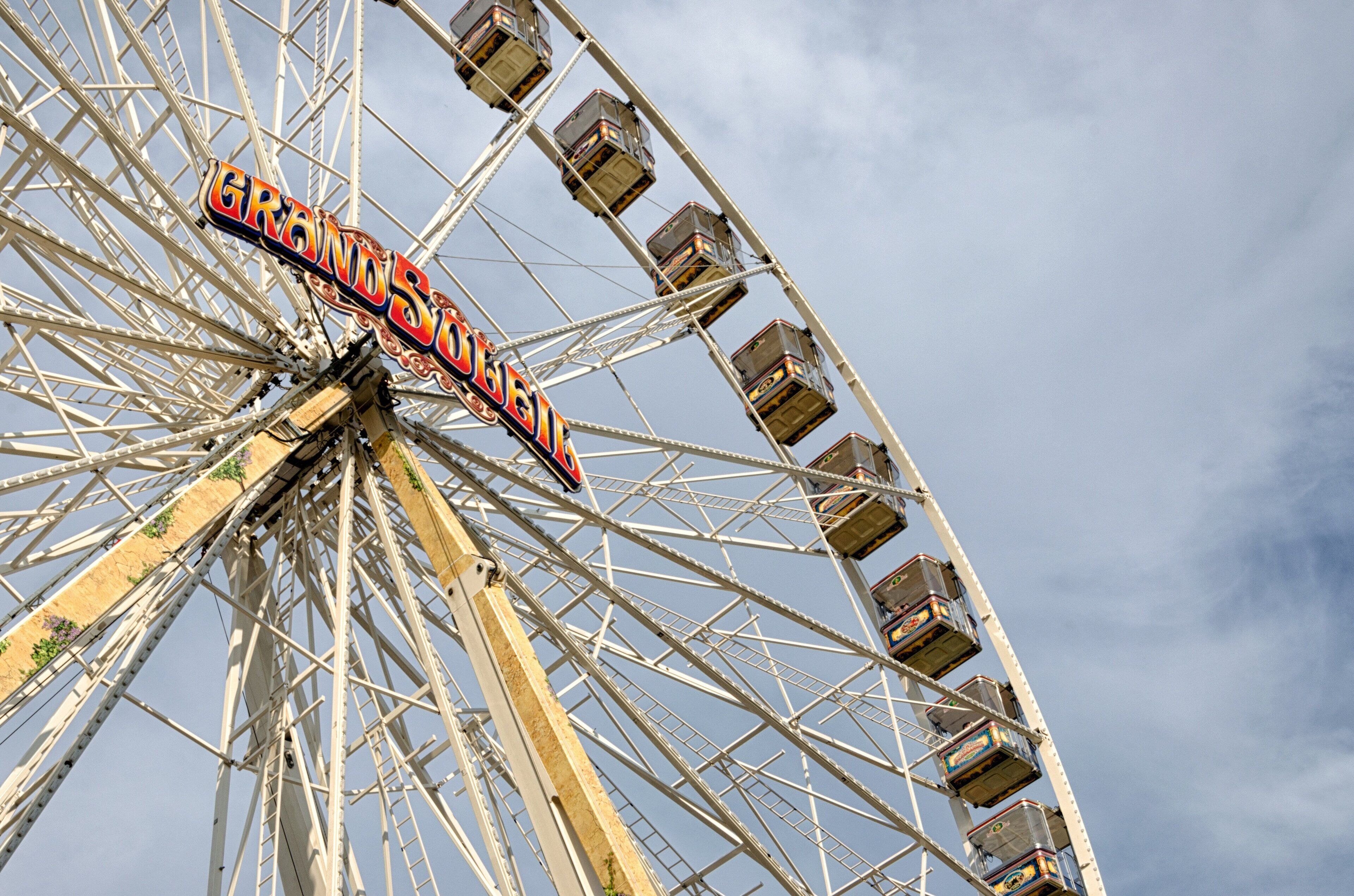 A Ferris wheel with cabins labeled "GRAND OBIE" against a clear sky.