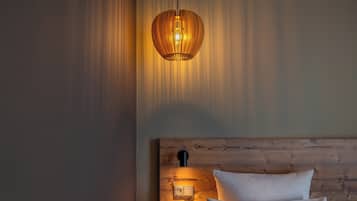 Une chambre à coucher avec une tête de lit en bois, une lampe de chevet et un luminaire suspendu.