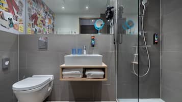 Een moderne badkamer met toilet, wastafel en douche.