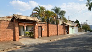 Una hilera de casas de ladrillo con tejados de tejas, una acera pavimentada y palmeras al fondo.