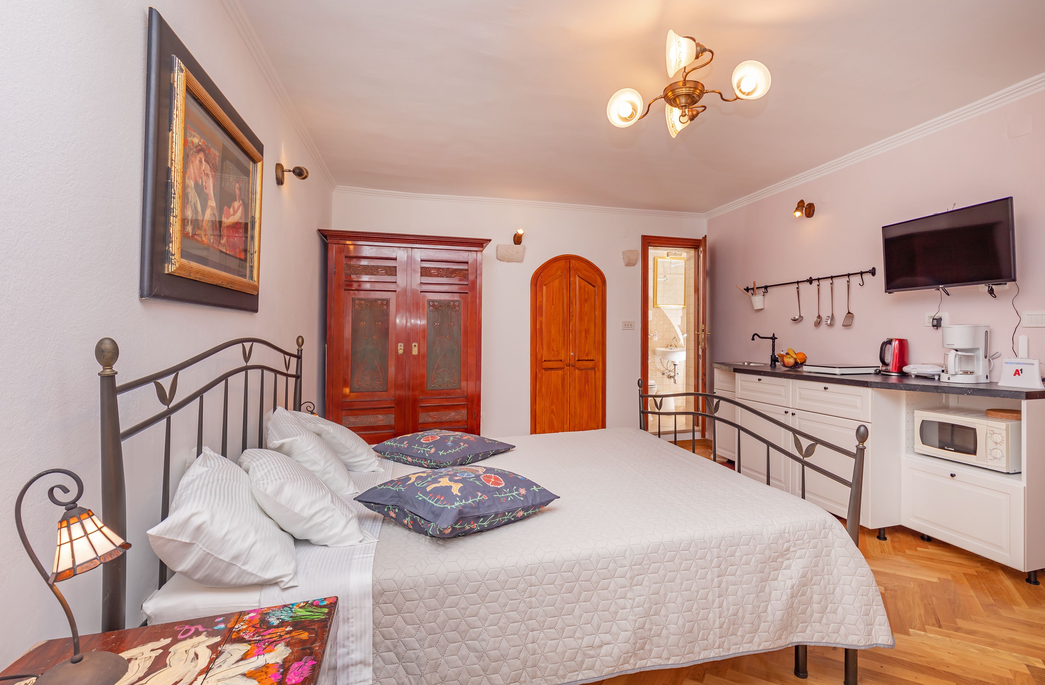 Une chambre à coucher avec un lit, une table de chevet, une lampe et un tableau au mur.