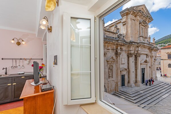 A room with a large window overlooking a historic building with ornate architecture.