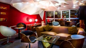 Uma sala de estar moderna com parede em destaque vermelha, mesa de centro de vidro e móveis contemporâneos.