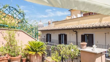 Un jardín en la azotea con plantas en macetas y una pérgola.