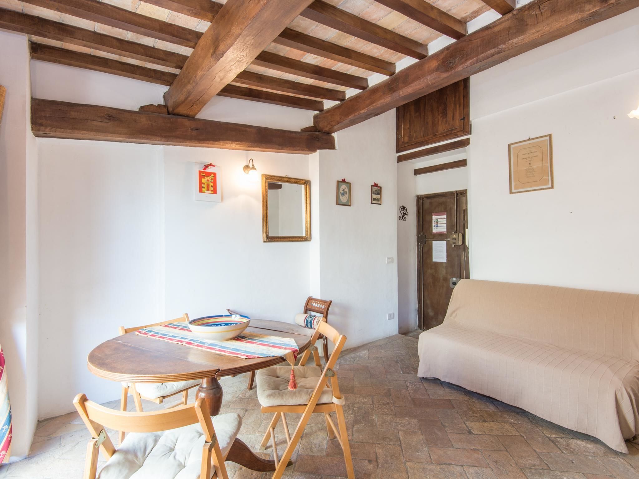 Un comedor con una mesa de madera, sillas y un sofá color beige.