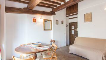Un comedor con una mesa de madera, sillas y un sofá color beige.