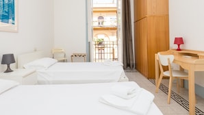 Une chambre d’hôtel avec deux lits, un bureau, une chaise, une lampe et une armoire.