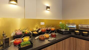 A buffet setup with various food items and condiments.
