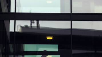 A modern building with large windows and a visible elevator.