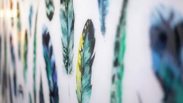 Una pared decorada con diversas obras de arte de plumas.