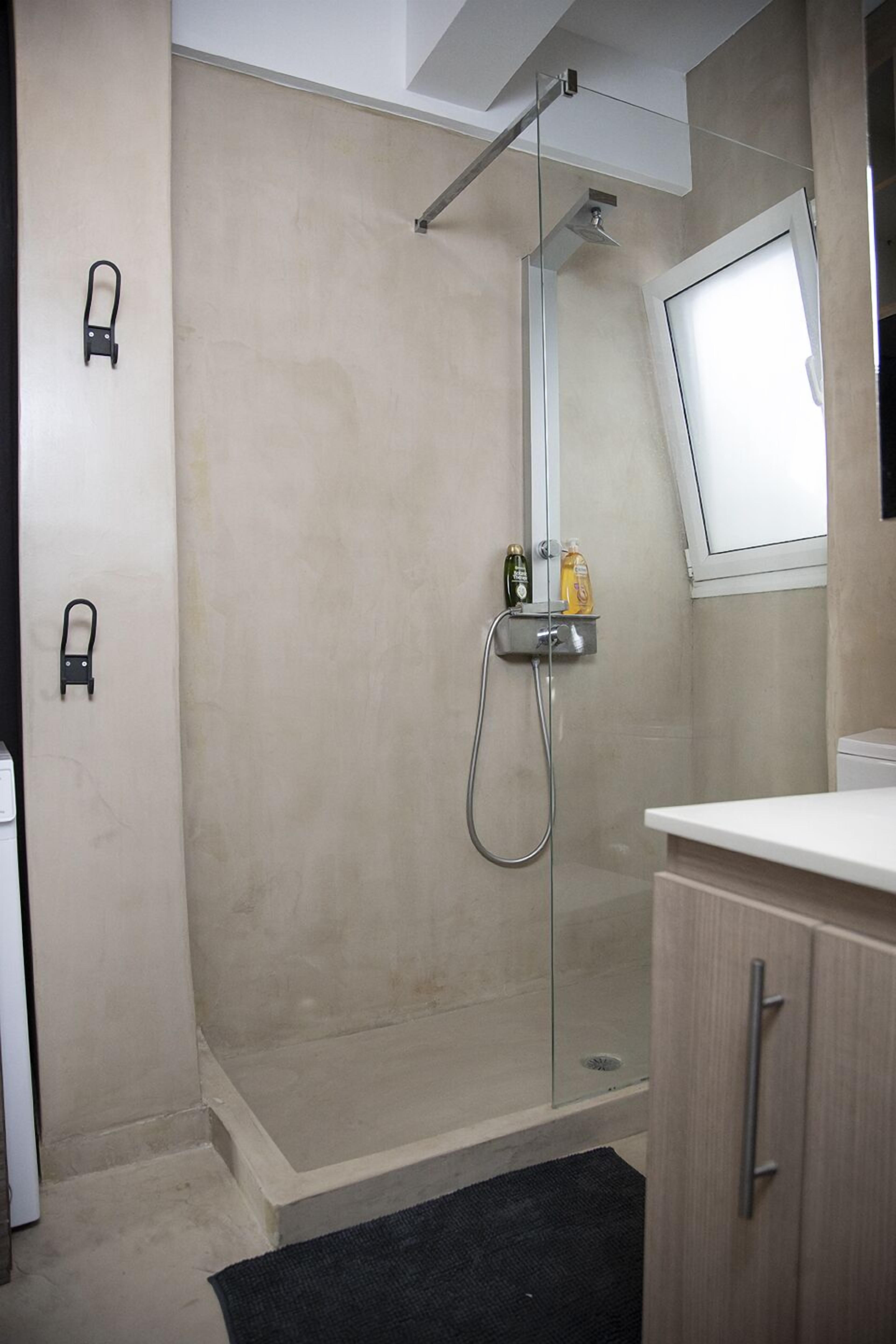 A modern bathroom with a glass-enclosed shower, a toilet, and a sink.