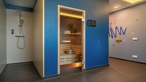 A modern bathroom with a shower, a blue wall, and a sign with text.