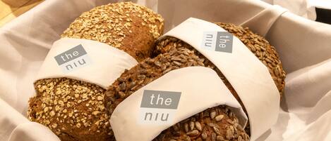 A selection of breads in a basket, each labeled with 'the niu'.
