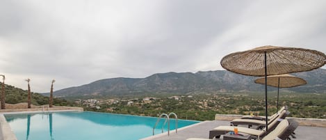 Una piscina al aire libre de temporada, sombrillas