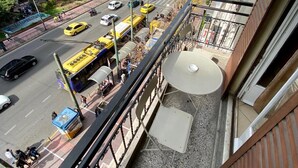A multi-story building with a balcony overlooking a busy street. - Artemision (Athens)
