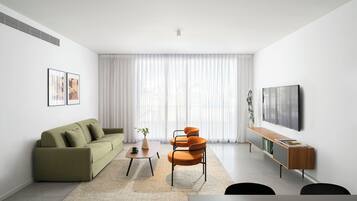 A modern living room with a sofa, a coffee table, a chair, a TV, and a bookshelf.