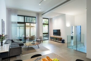 A modern living room with a sofa, coffee table, and TV. - master Shenkin (Tel Aviv)