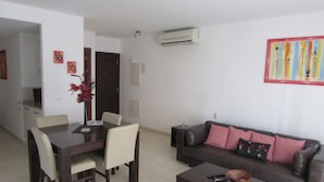 A living room with a dining table, chairs, a sofa, and a coffee table. - Private Self-Catering Apartments (Sal)