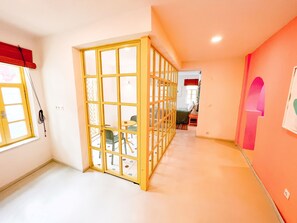 A hallway with a sliding door leading to a room with a bed and a chair. - Bono Hotel Old Town (Marmaris)