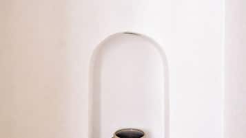 A white wall with a small alcove containing a ceramic mug.
