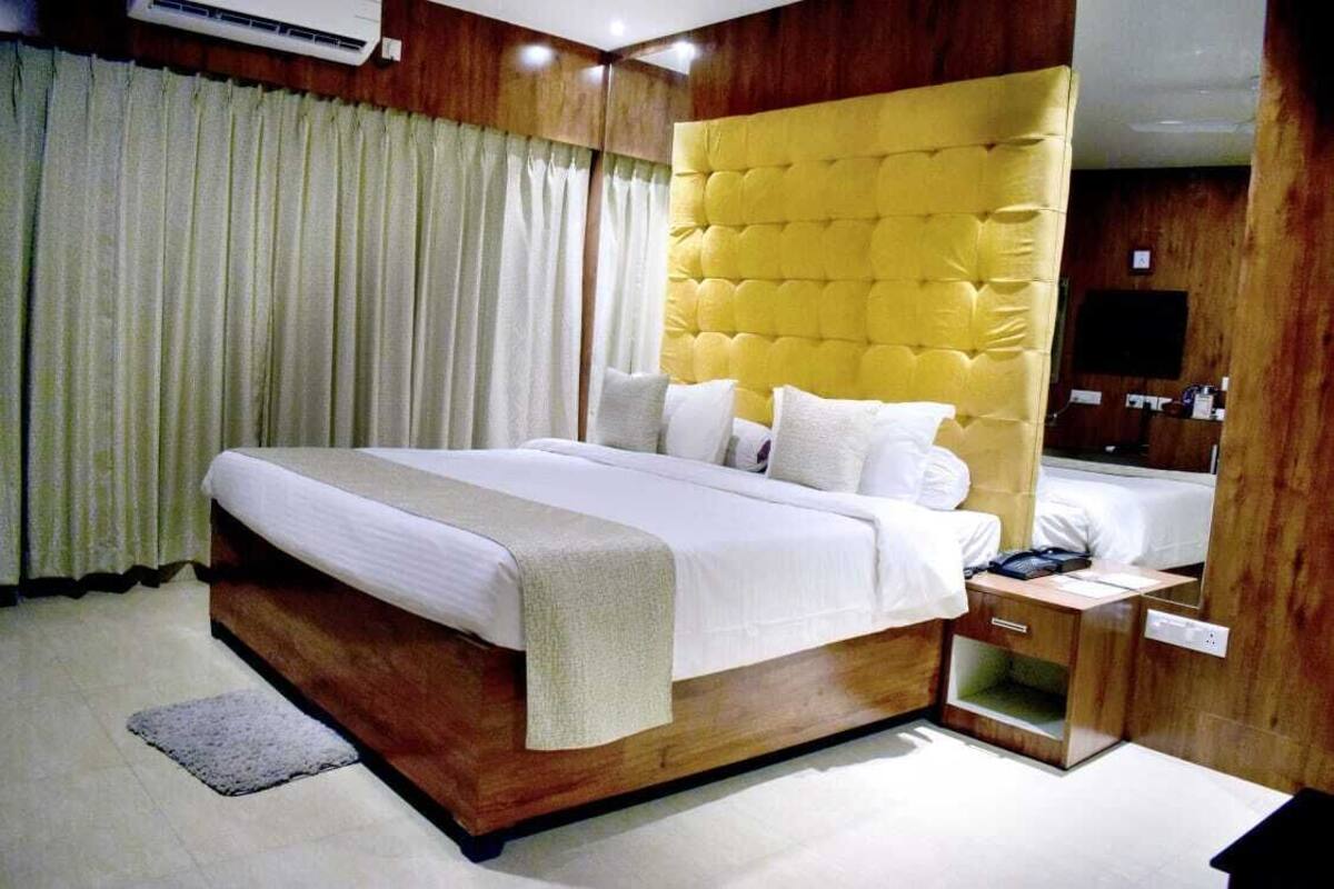 Un dormitorio moderno con una cama grande, cabecera de madera y una mesita de noche.