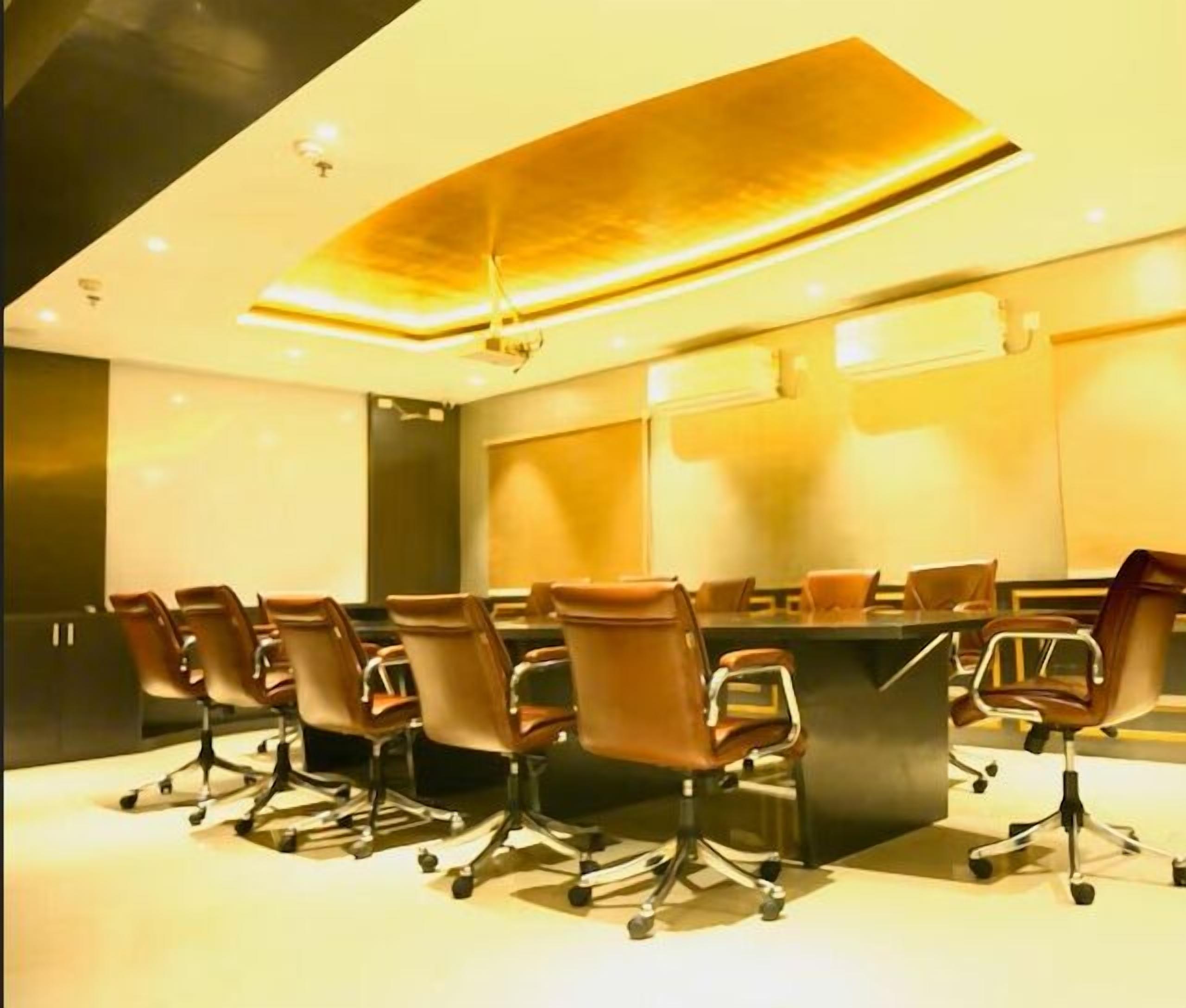 A conference room with a long table and multiple chairs.