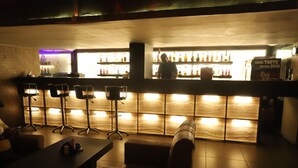 En bar med disk, barstole og et bord.