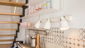 A kitchen with white cabinets, hanging utensils, and a stainless steel coffee maker. - Apartment Shiny Love (Split)