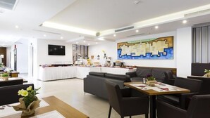 A modern hotel lobby with a dining area, a sofa, and a large abstract painting on the wall. - Apartment Shiny Love (Split)