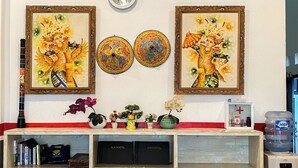 A reception desk with framed artwork, a clock, and a water dispenser.